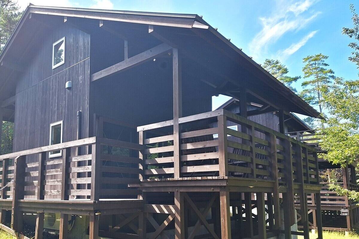 Une cabane en bois avec un balcon, une fenêtre et une porte.