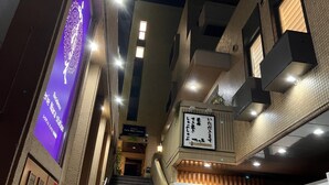 A multi-level building with a staircase, signs indicating a residence and a station, and a wooden sign with Japanese characters. - Residence Ferie Nara Station (Nara)