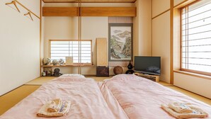 A traditional Japanese room with tatami flooring, a television, and a painting of a mountain landscape. - Residence Ferie Nara Station (Nara)