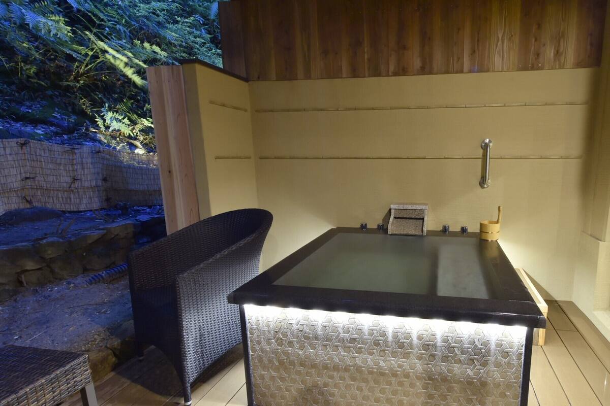 Un espacio de spa con un jacuzzi, una pared de madera y una pared de piedra.