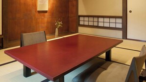 A conference room with a wooden panel wall, a large red table, and traditional Japanese sliding doors.