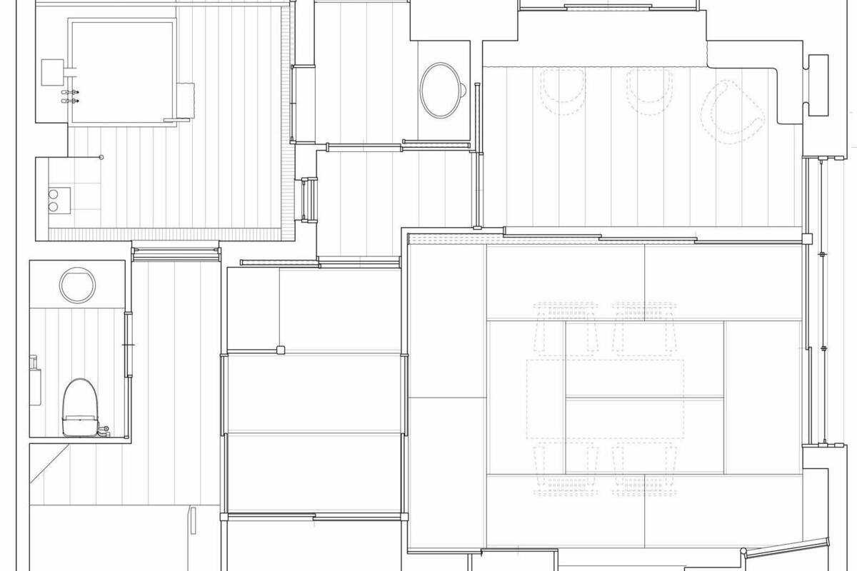 Un plano de planta que muestra varias habitaciones, incluyendo una zona central amplia posiblemente para eventos, varias habitaciones más pequeñas y un área de cocina.