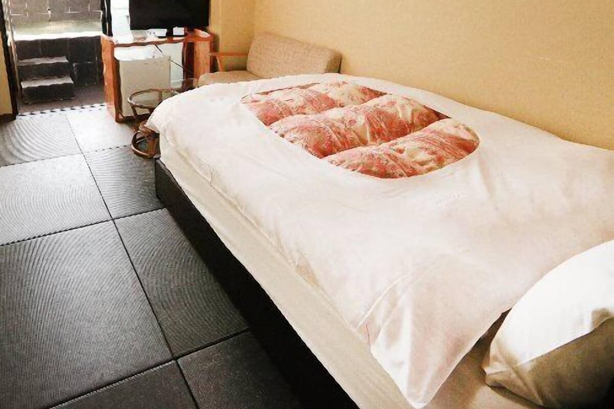 A hotel room with a bed, a television, a desk, and a view of the outside.