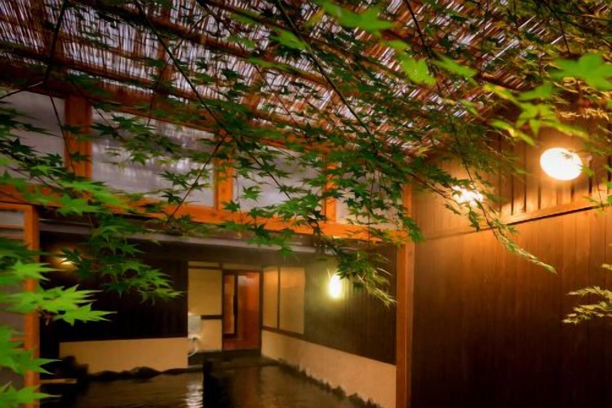 A traditional Japanese interior with tatami flooring, a wooden sliding door, and a stone lantern.