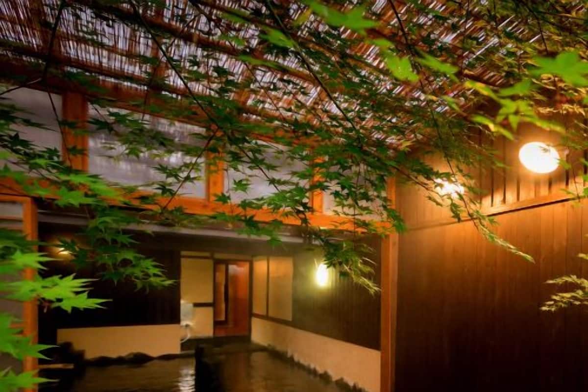 A traditional Japanese interior with tatami flooring, a wooden sliding door, and a stone lantern.