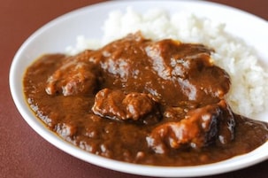 Un plato de curry con carne y arroz.