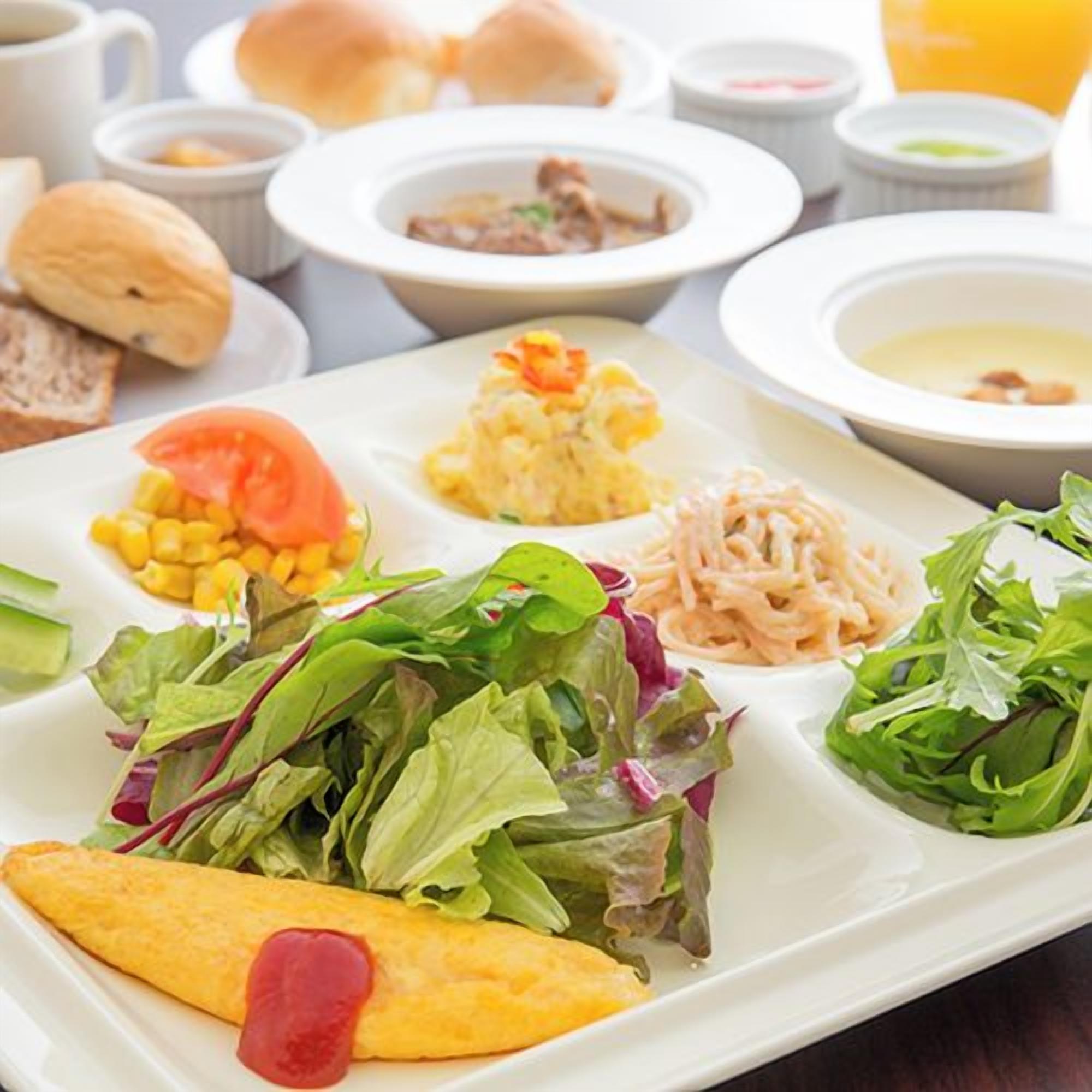 A variety of dishes including a salad, a sandwich, and a bowl of soup.