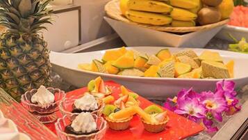 A buffet with various fruits and desserts.
