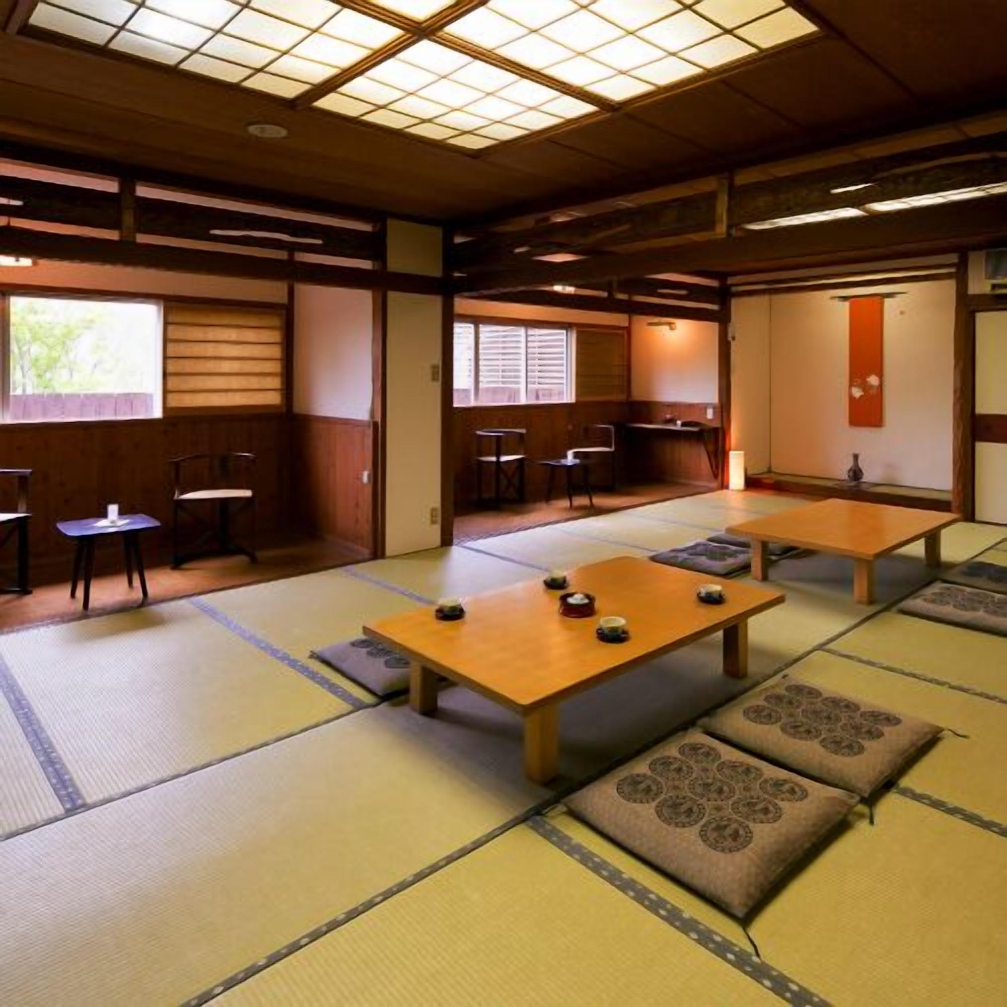 A traditional Japanese room with tatami flooring, low tables, and sliding doors.