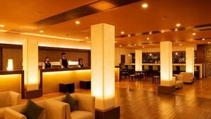 A hotel lobby with a reception desk, seating area, and bar. - Asouchinomaki Onsen Yumeoiso (Aso)