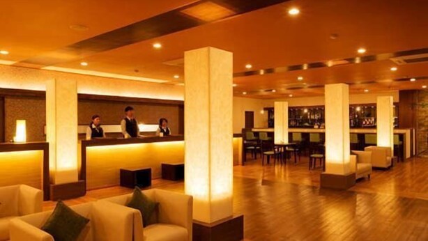 Eine Hotelhalle mit Rezeption, Sitzbereich und Bar.