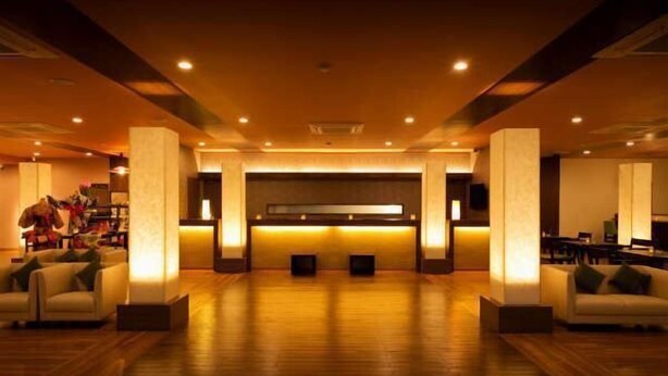 A spacious lobby with a reception desk, seating area, and a large window. - Asouchinomaki Onsen Yumeoiso (Aso)