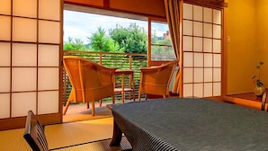 A traditional Japanese room with tatami flooring, a low table, and sliding doors. - Shinkanou Gourmet Ryokan (Izunokuni)