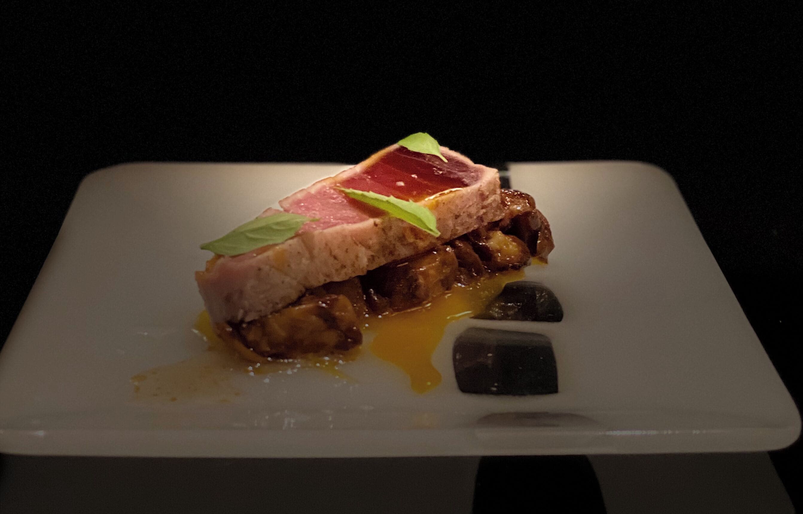 A dessert on a white plate with a dark background.