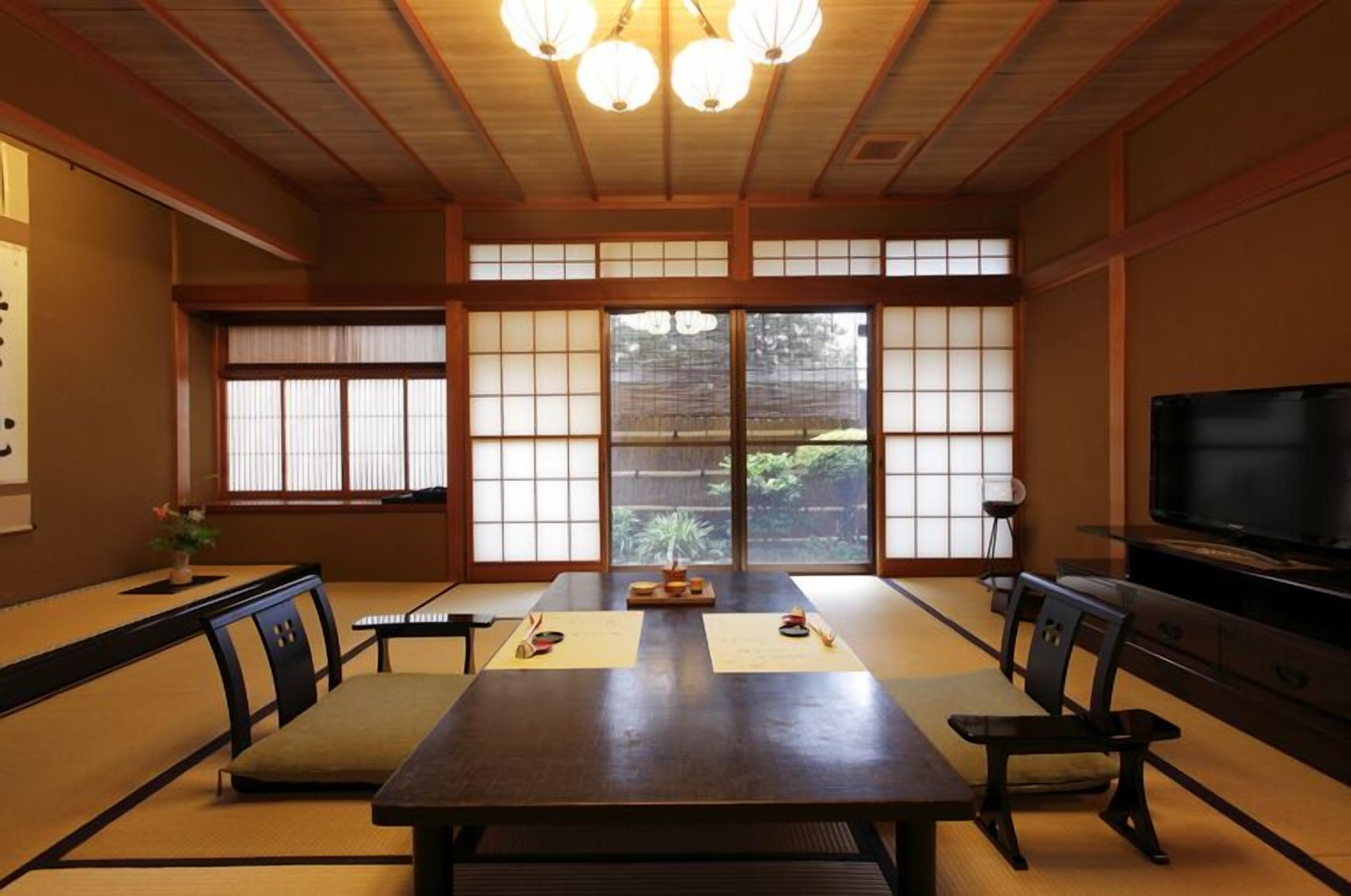 A traditional Japanese room with tatami flooring, a low table, and sliding doors.