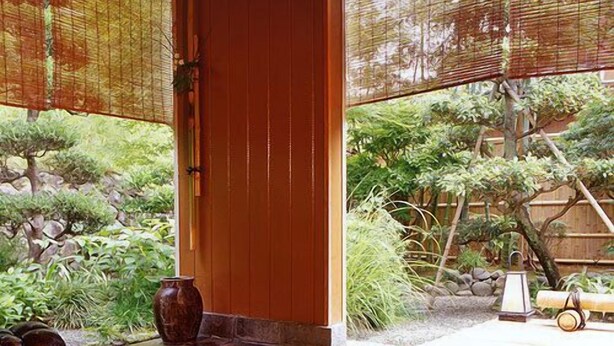 A traditional Japanese interior with tatami flooring, a wooden door, and a view of a garden with rocks and plants. - Shinkanou Gourmet Ryokan (Izunokuni)
