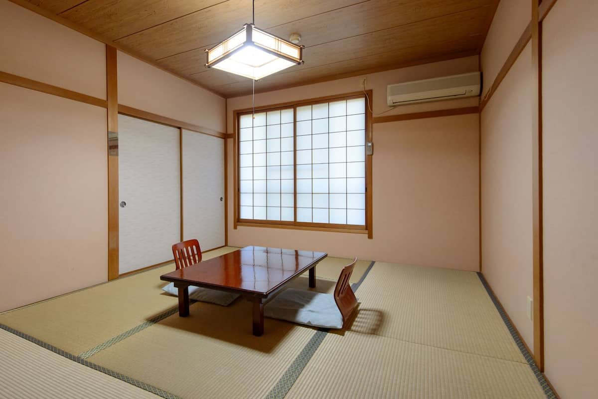 Egy hagyományos japán szoba, tatami szőnyeggel, alacsony asztallal és tolóajtókkal.