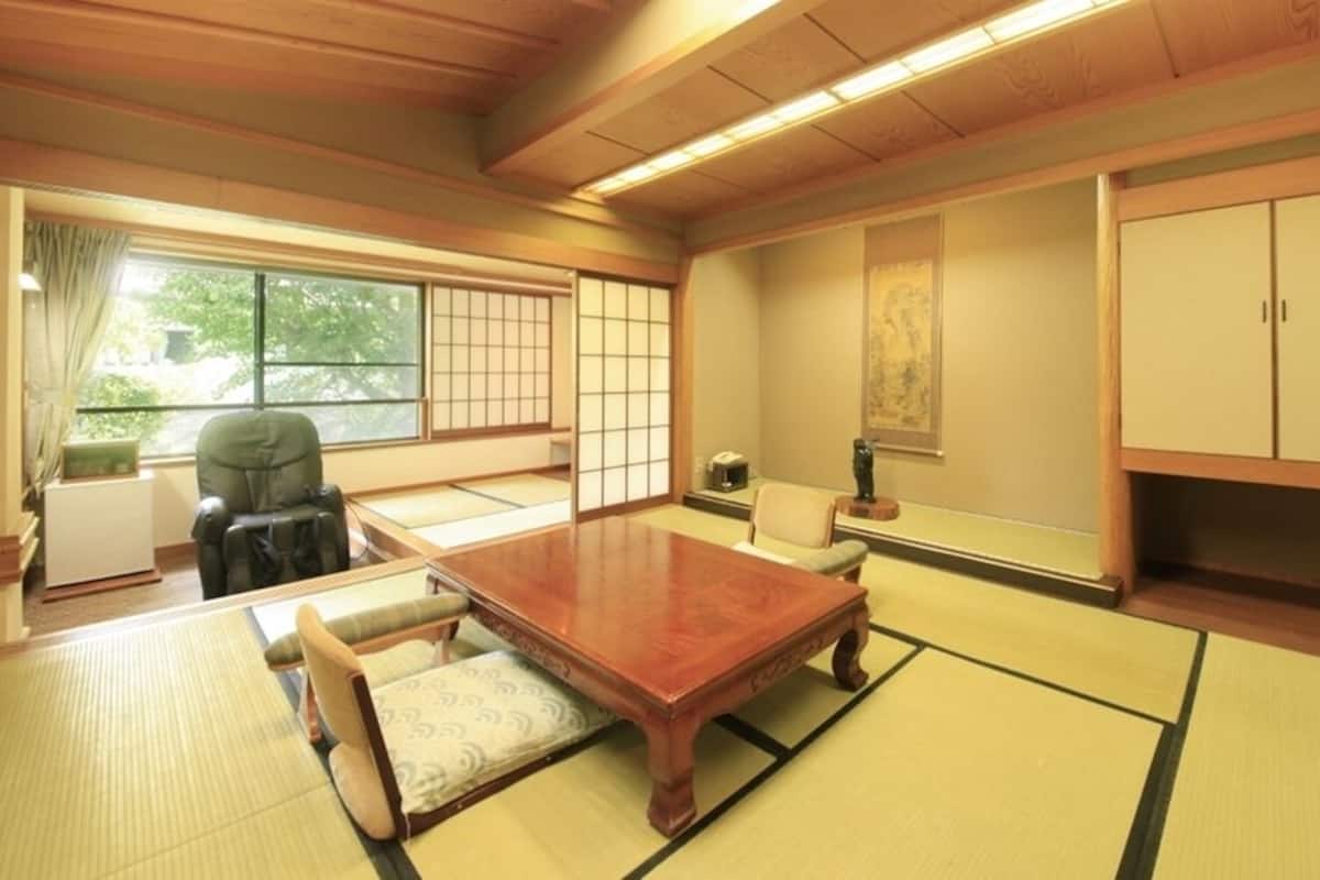 A traditional Japanese room with tatami flooring, a low wooden table, and a sliding door.