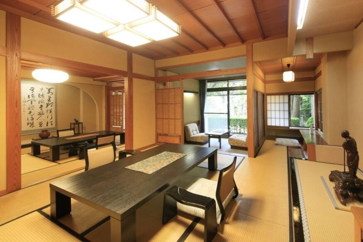 A traditional Japanese room with tatami flooring, a low table, and a statue.