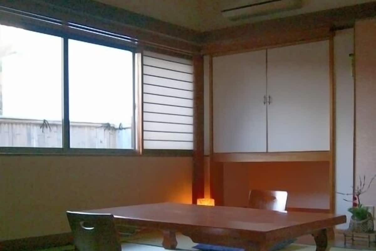A traditional Japanese room with tatami flooring, a low table, and sliding doors.