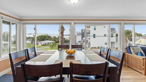 Comedor con mesa, sillas y un cuenco de fruta.
