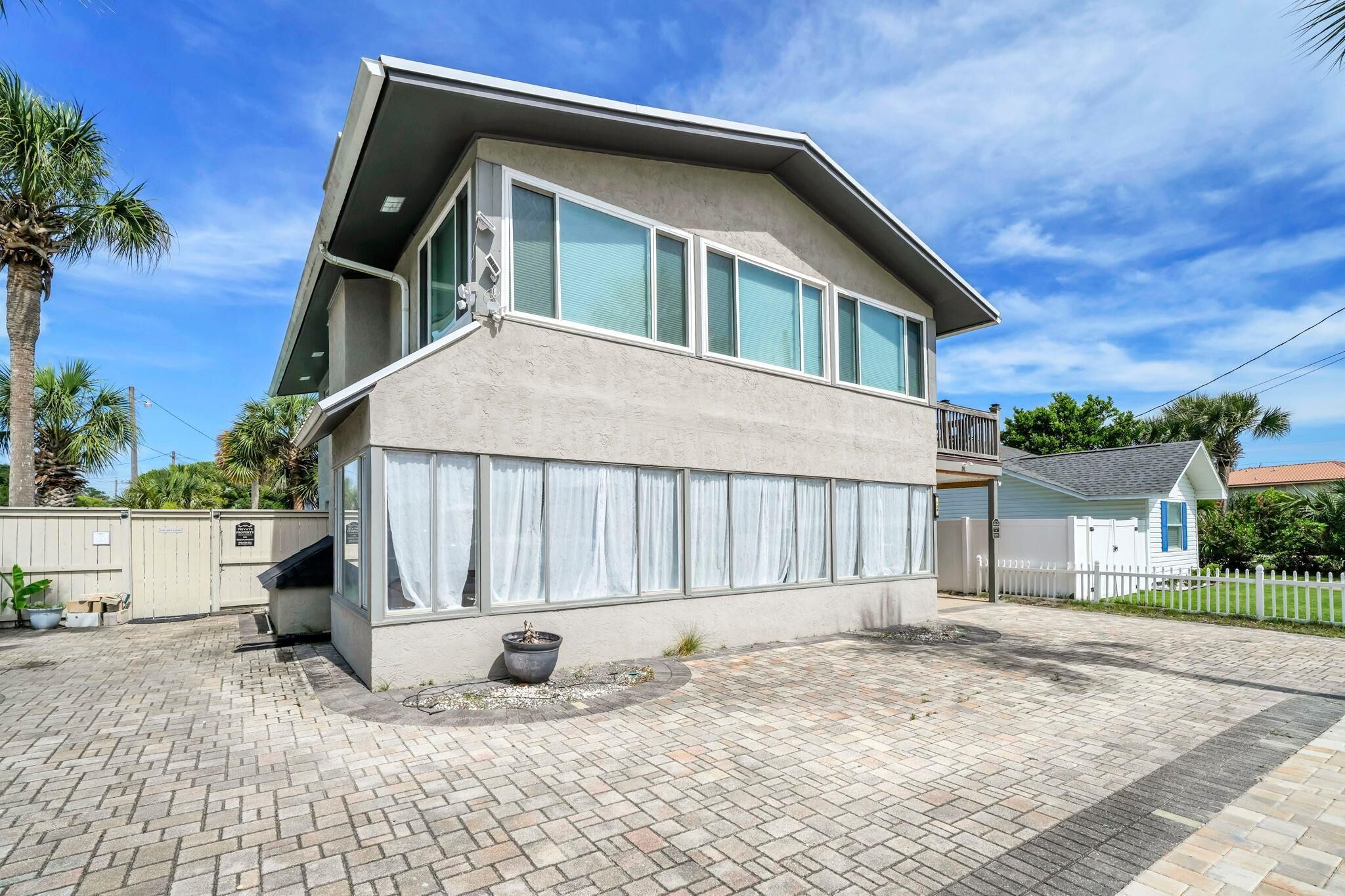 A two-story building with large windows, a flat roof, and a paved driveway.