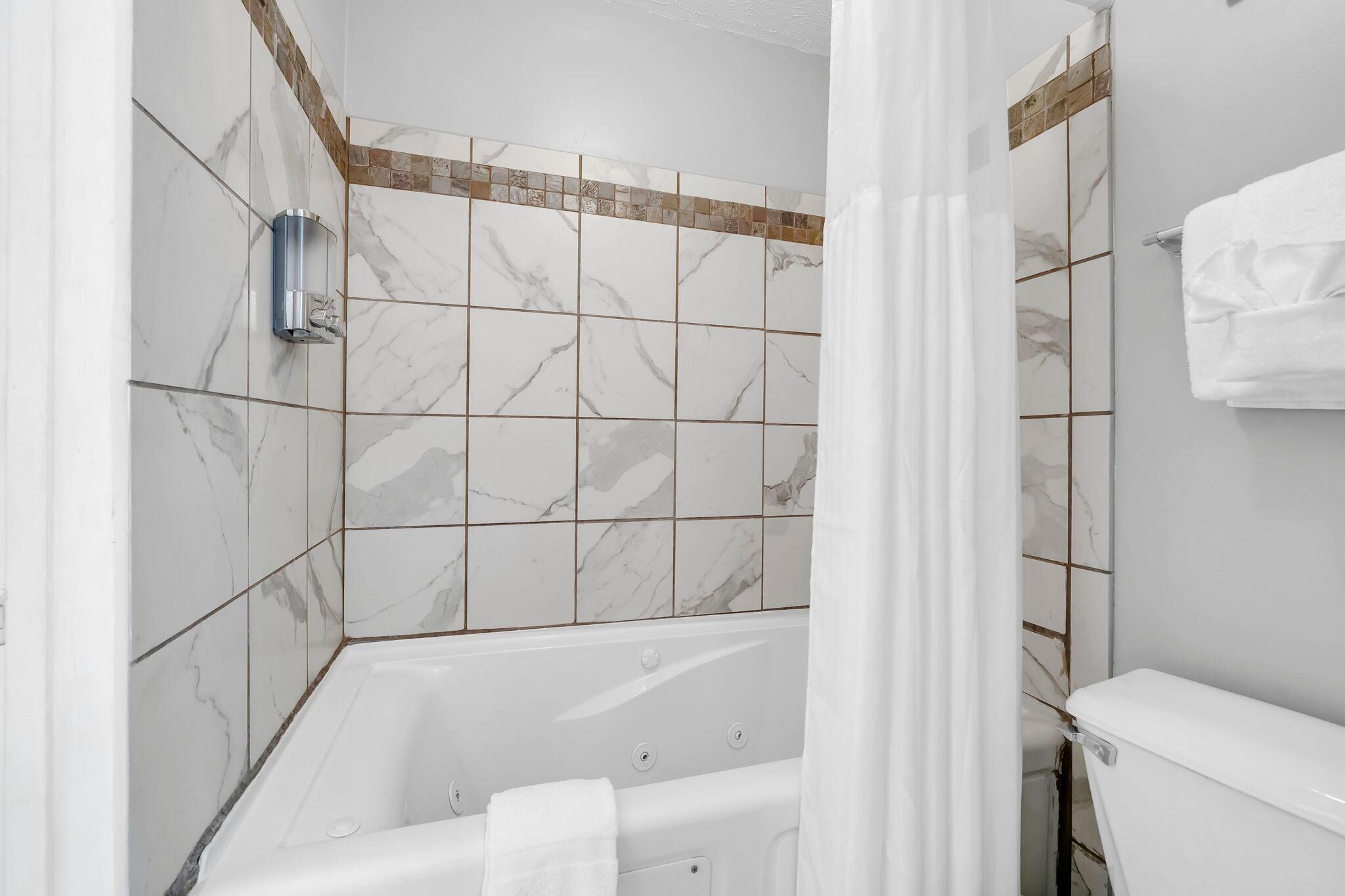 Une salle de bain équipée d’une baignoire, de toilettes et d’un espace douche.