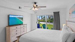 A bedroom with a bed, a television on a dresser, and a view of the outdoors. - Maravilla 3108 (Miramar Beach)