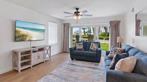 A living room with a TV, sofa, and a ceiling fan. - Maravilla 3108 (Miramar Beach)