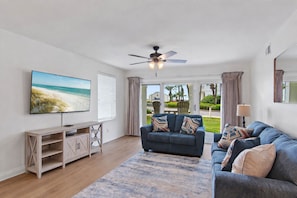 A living room with a TV, sofa, and a ceiling fan. - Maravilla 3108 (Miramar Beach)