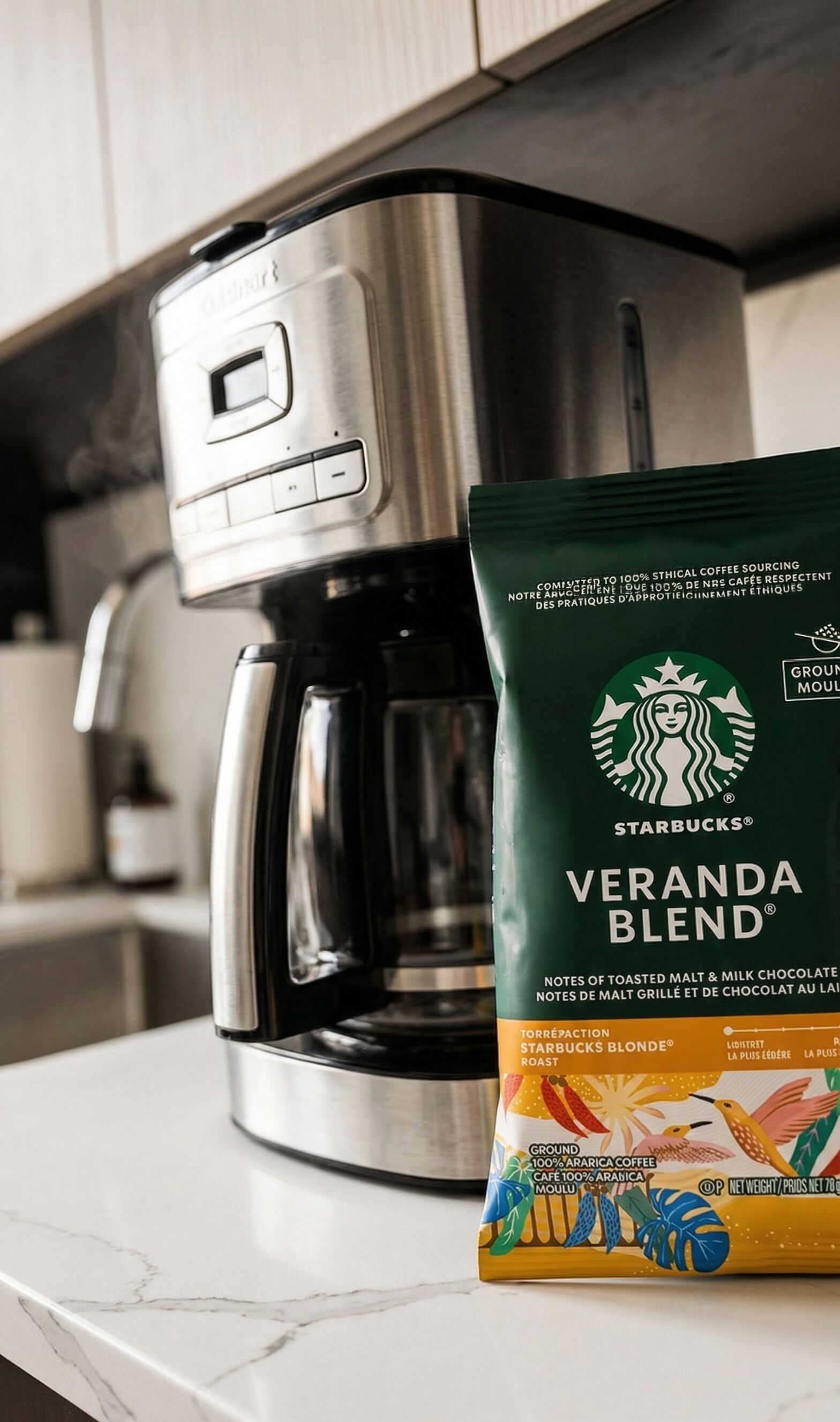Una cafetera y un paquete de café Starbucks Veranda Blend sobre una encimera de cocina.