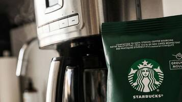 A coffee maker and a Starbucks Veranda Blend coffee bag on a kitchen counter.