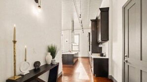 A modern kitchen with dark cabinetry, a wooden floor, and a central island.
