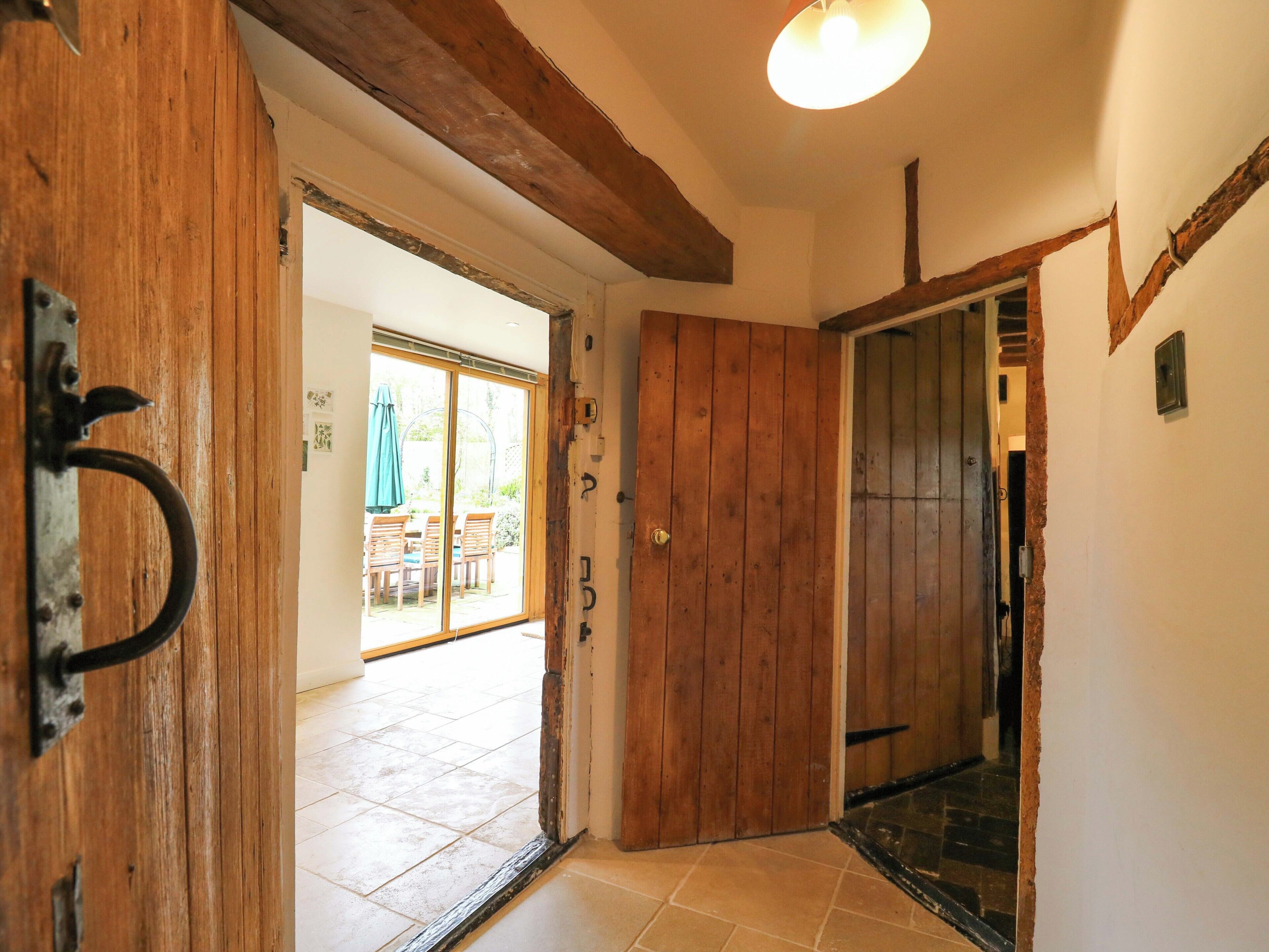A wooden door leading to a patio area with a table and chairs.