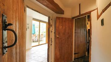 A wooden door leading to a patio area with a table and chairs.