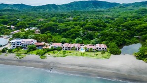 A coastal resort with multiple buildings, a beach, and a forested area in the background. - Beachfront Condo•BBQ•pool•prime location•sleeps 4 - Pacific Beach 9 (Potrero)