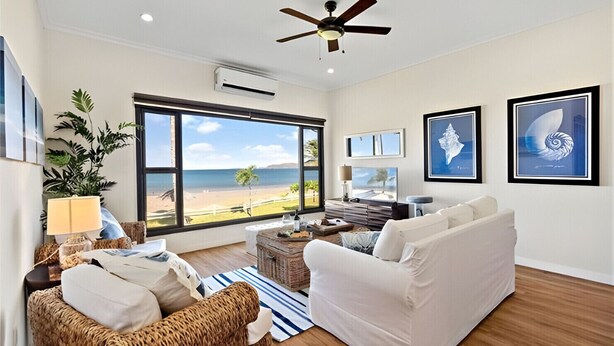 A spacious living room with a large window overlooking a beach, a ceiling fan, and a modern fireplace. - Beachfront Condo•BBQ•pool•prime location•sleeps 4 - Pacific Beach 9 (Potrero)
