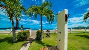 A pathway leading to a beach with palm trees, a wooden deck, and a white wall with a door. - Beachfront Condo•BBQ•pool•prime location•sleeps 4 - Pacific Beach 9 (Potrero)