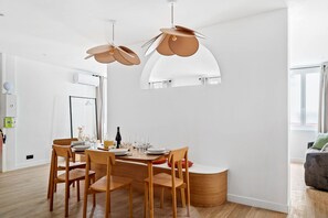 Un espace de restauration moderne avec une table ronde, des chaises en bois et des luminaires suspendus.
