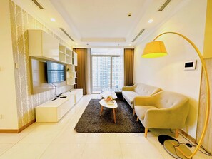 Una sala de estar moderna con un sofá, una mesa de centro, televisor y estanterías empotradas.