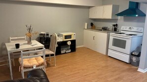 A compact kitchen with a microwave, stove, and cabinets.