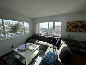 A living room with a sofa, a coffee table, and a painting on the wall.