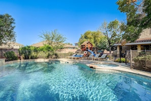 A clear swimming pool with lounge chairs and a wooden play structure. - Luxe 6Br Home Large 40ft Pool & Spa, Mini Golf, RV Parking (Las Vegas)