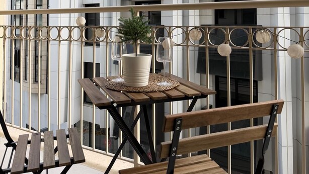 A balcony with a table, chairs, a potted plant, and a railing. - Luxury 2BR Apartment · 1 min to Beach (Larnaka)