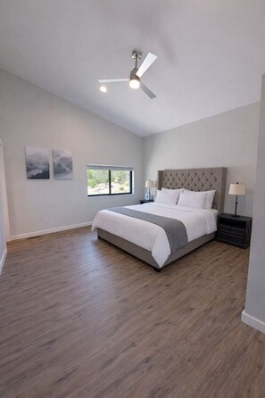 A bedroom with a bed, a ceiling fan, a window, and artwork on the wall. - New build Luxe escape w Heated Pool, Hot Tub, Fire Pit, State Park and Beaches (Stevensville)