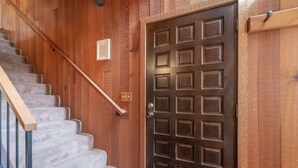 A wooden staircase leading to a dark brown door with a grid pattern. - Family-Friendly Retro Townhouse 1 Mile from Lake (Kings Beach)