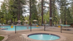 A pool area with lounge chairs, a hot tub, and a fenced deck. - Family-Friendly Retro Townhouse 1 Mile from Lake (Kings Beach)
