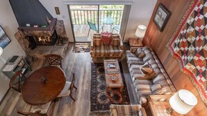 A cozy living room with a fireplace, a dining table, and a sofa set. - Family-Friendly Retro Townhouse 1 Mile from Lake (Kings Beach)