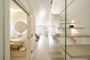 Un intérieur moderne comprenant une salle de bain, un escalier et un espace de vie.
