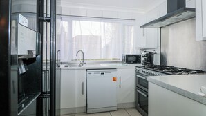 A modern kitchen with a dishwasher, microwave, stove, and oven. - The Retreat (Deal)